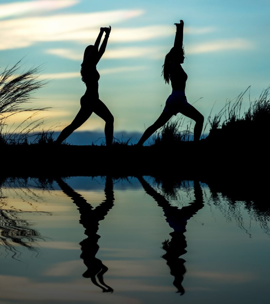 Twee persone wat joga beoefen en hul weerkaatsings